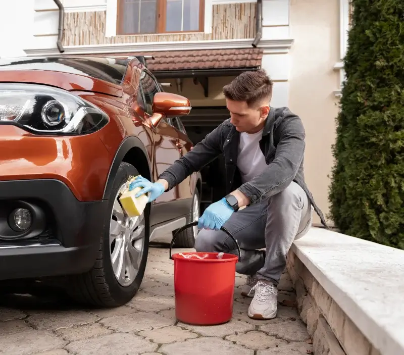 Lavage auto à domicile Vienne-en-Arthies : professionnel intervenant sur un véhicule